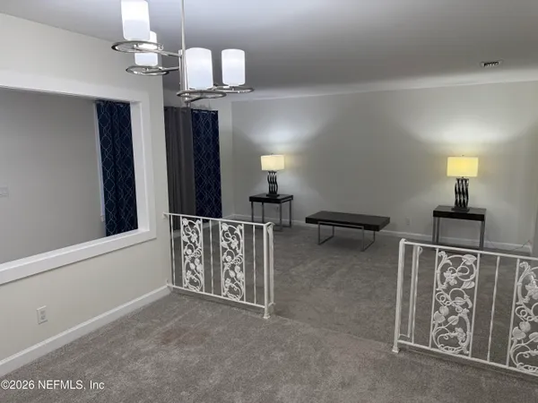 a view of a hallway with a large mirror on a dresser