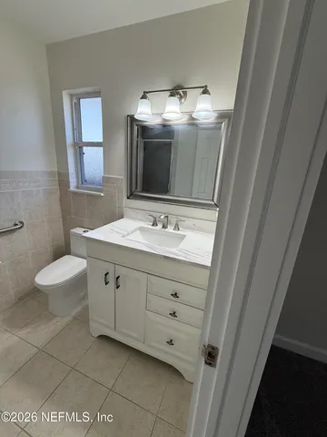 a bathroom with a double vanity sink a toilet and a mirror