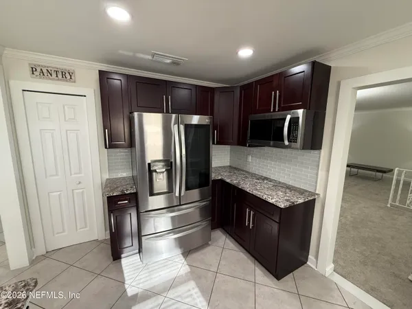 a kitchen with stainless steel appliances granite countertop a refrigerator and a stove