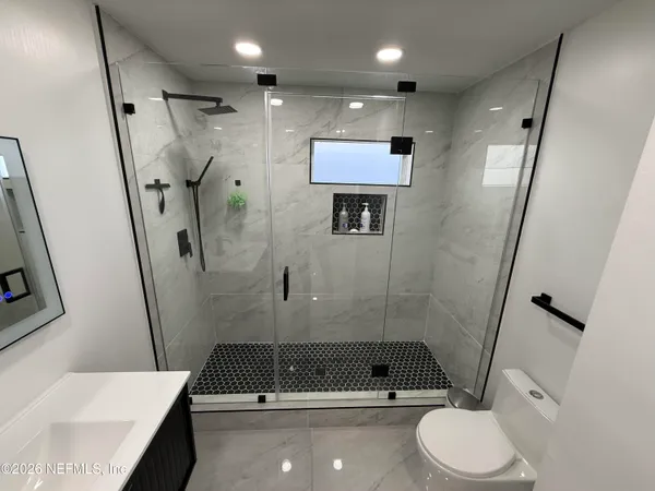 a bathroom with a shower a toilet and a sink