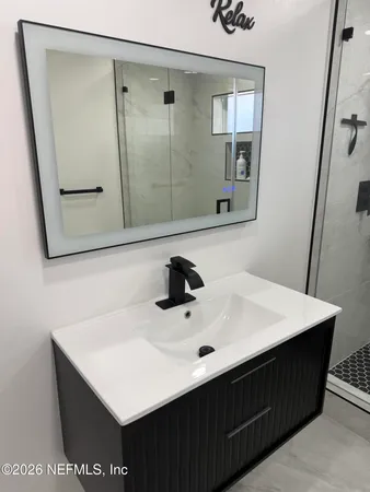 a bathroom with a sink vanity and a mirror