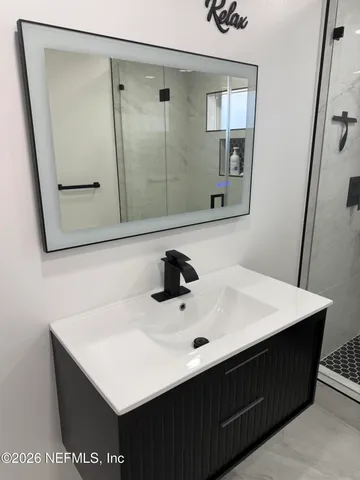 a bathroom with a sink vanity and a mirror