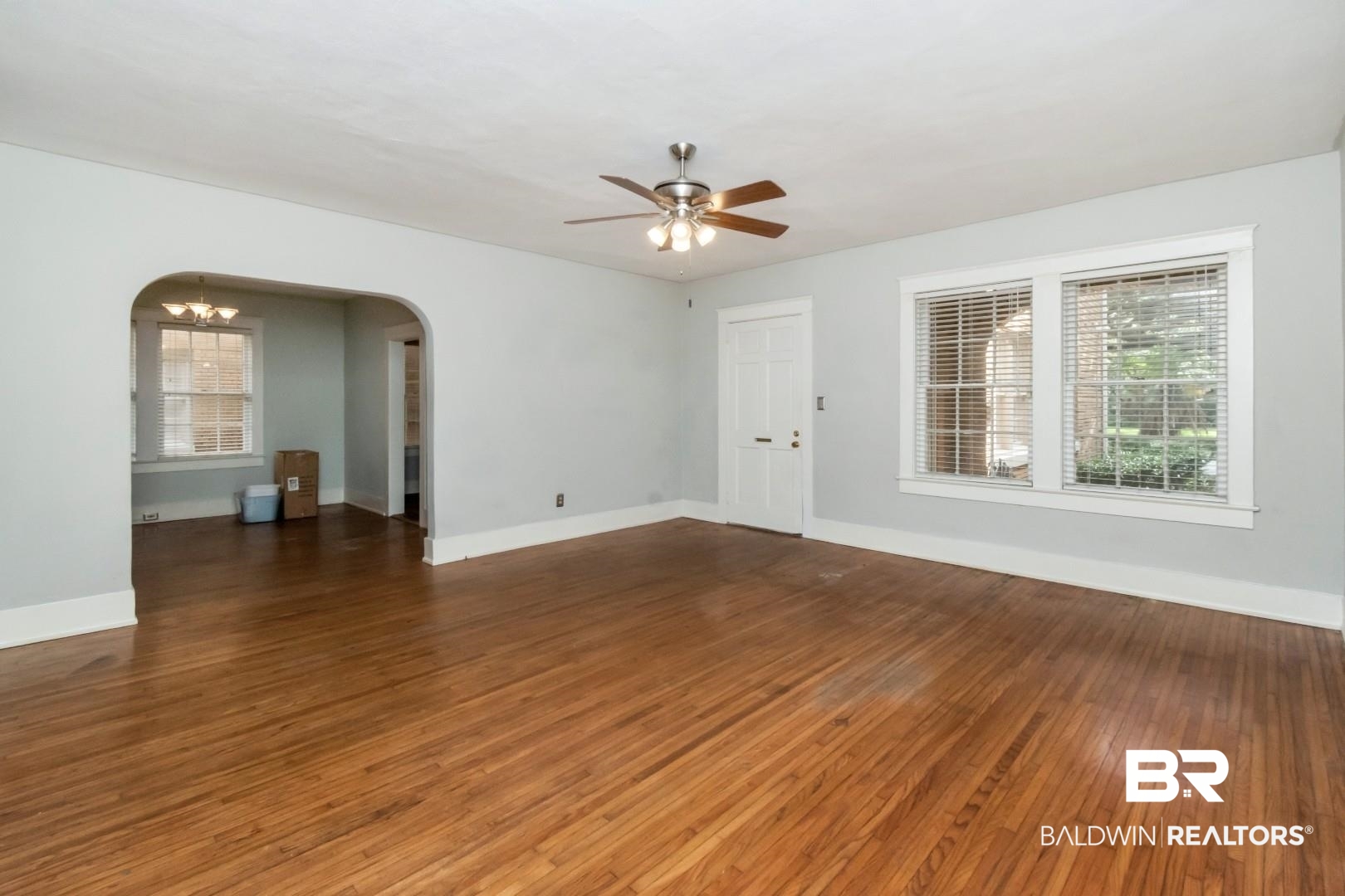1602 Government Street, Unit 1A Mobile, AL 36604 - Photo 4 of 24 Empty room with dark wood-type flooring, a chandelier, arched walkways, and ceiling fan