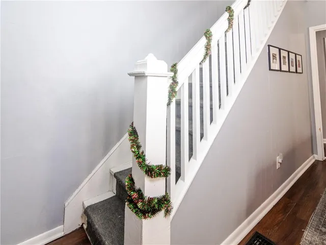 a view of staircase with wooden floor and white walls