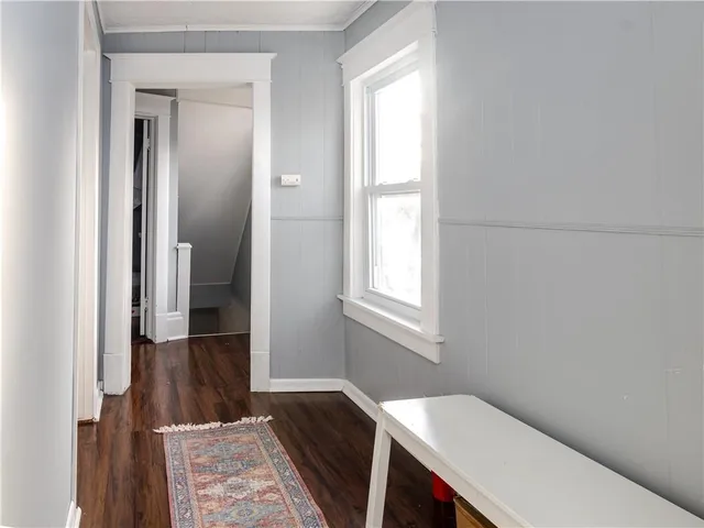 a hallway with wooden floor and a window