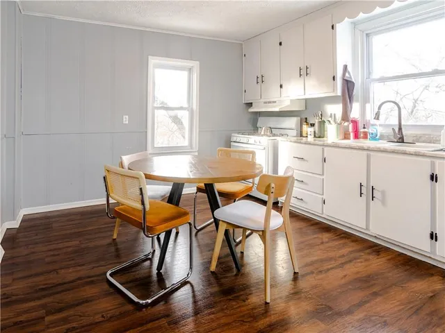 a kitchen with a dining table chairs and white cabinets