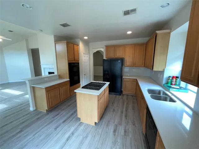 a kitchen with sink cabinets and wooden floor
