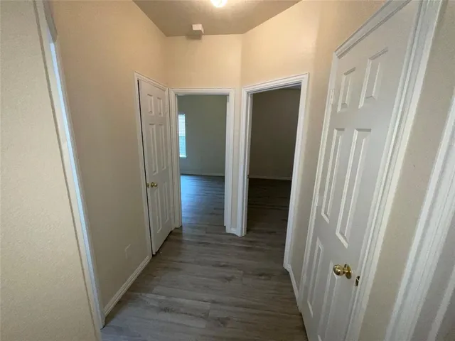 a view of a hallway with wooden floor