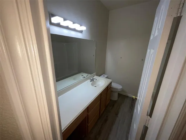a bathroom with a sink and mirror with toilet
