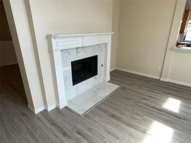 a view of a livingroom with wooden floor and a fireplace