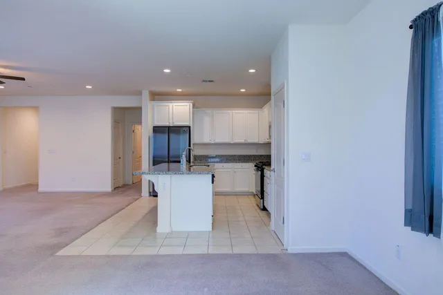 a view of an empty room and kitchen view