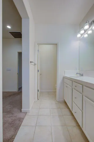 a spacious bathroom with a mirror and a sink