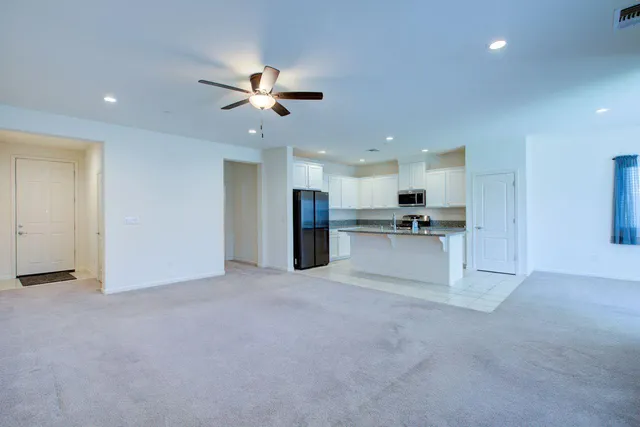a view of a kitchen with kitchen island a sink stainless steel appliances and a counter top space