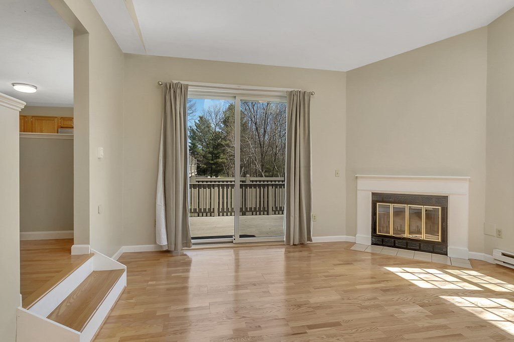 307 Ridgefield Circle, Unit A Clinton, MA 01510 - Photo 15 of 42 a view of an empty room with a fireplace and a window
