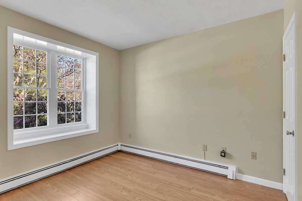 307 Ridgefield Circle, Unit A Clinton, MA 01510 - Photo 17 of 42 a view of an empty room with a window and wooden floor