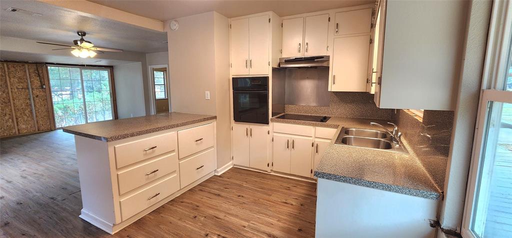 2016 Gavin Road Tool, TX 75143 - Photo 9 of 26 Kitchen with white cabinetry, built-in oven, integrated cooktop, double basin sink, and vinyl flooring
