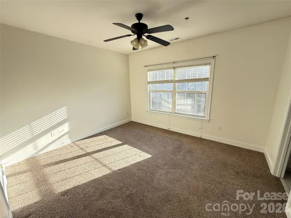 a view of a livingroom with a ceiling fan and window