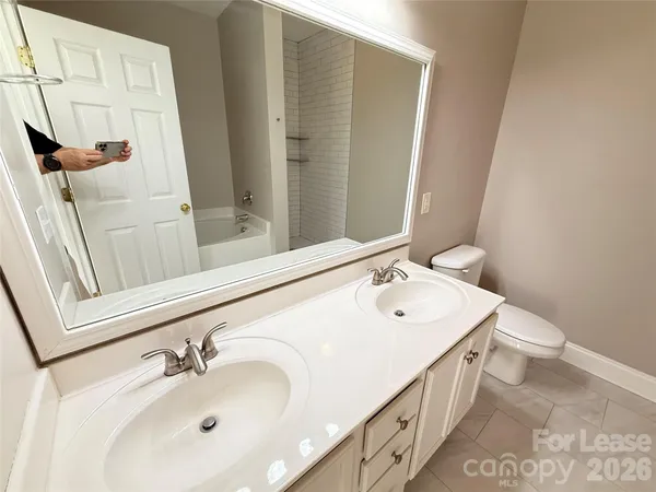 a bathroom with a sink and mirror with toilet
