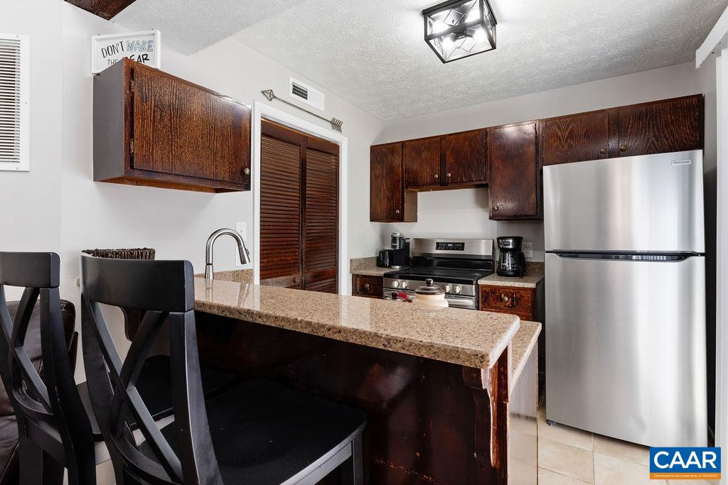 487 3 Ridges Roseland, VA 22967 - Photo 5 of 20 a kitchen with stainless steel appliances granite countertop a refrigerator a sink a stove a dining table and chairs