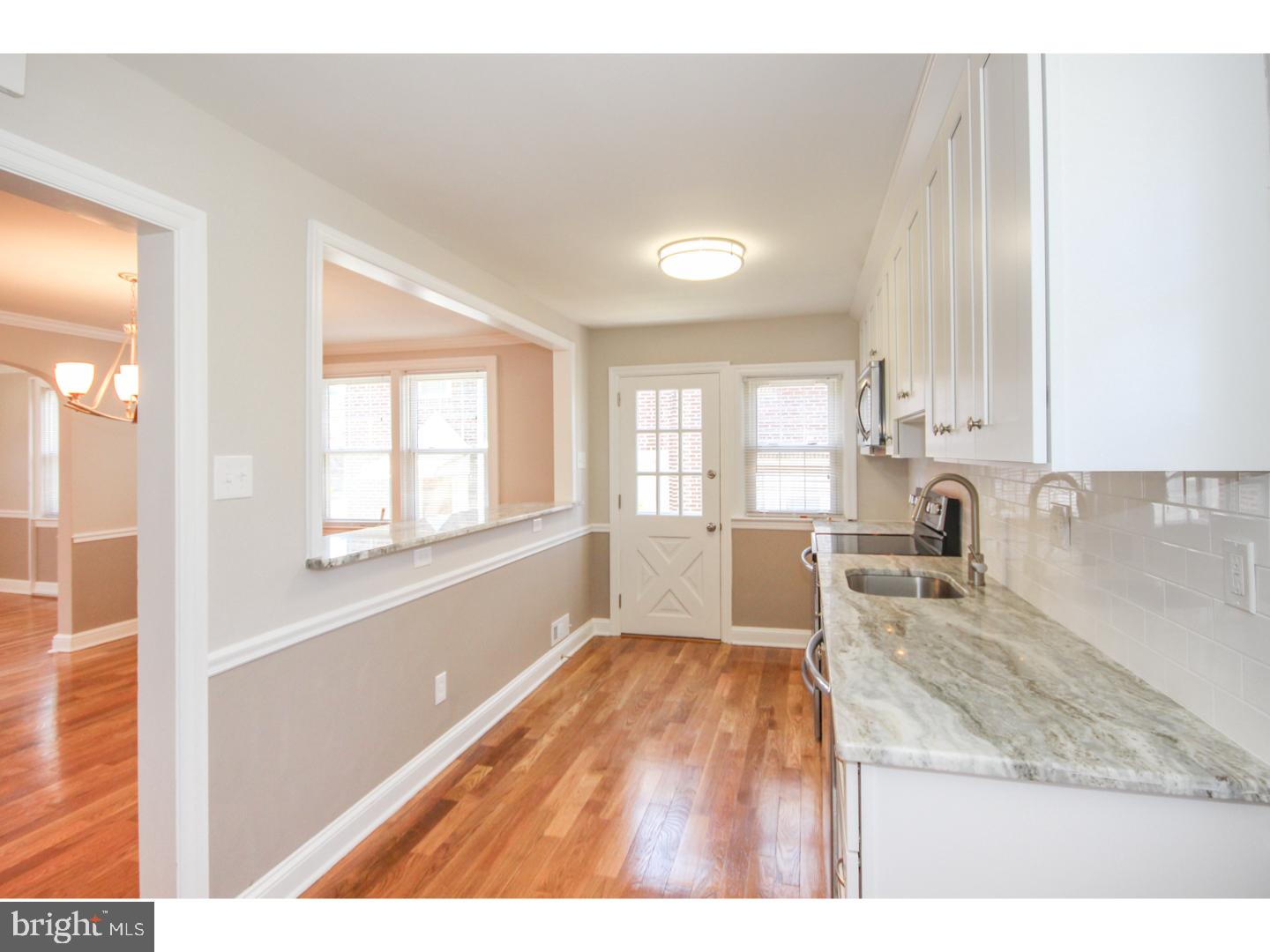 346 Ballymore Road Springfield, PA 19064 - Photo 8 of 24 a open kitchen with granite countertop white cabinets and wooden floor