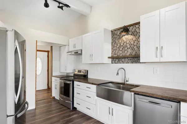 a kitchen with stainless steel appliances granite countertop a sink stove and refrigerator