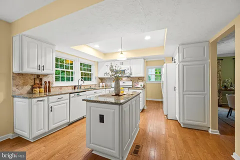 a kitchen with granite countertop a stove top oven and cabinets