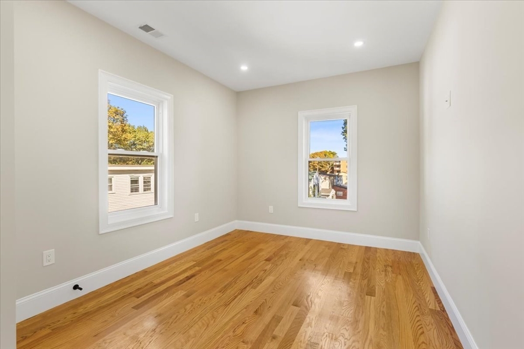 31 Woodale Avenue, Unit 2 Boston, MA 02126 - Photo 11 of 16 a view of an empty room with window and wooden floor