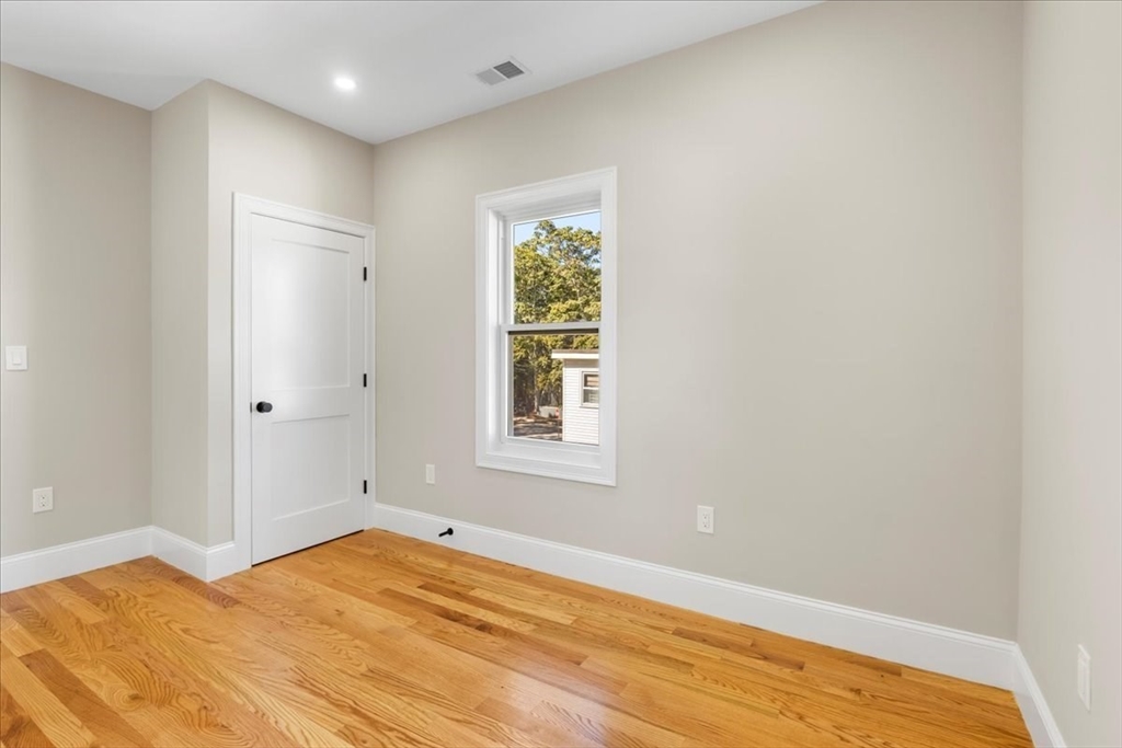 31 Woodale Avenue, Unit 2 Boston, MA 02126 - Photo 12 of 16 a view of an empty room with wooden floor and a window