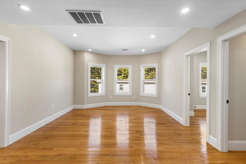 31 Woodale Avenue, Unit 2 Boston, MA 02126 - Photo 2 of 16 a view of an empty room with window and wooden floor