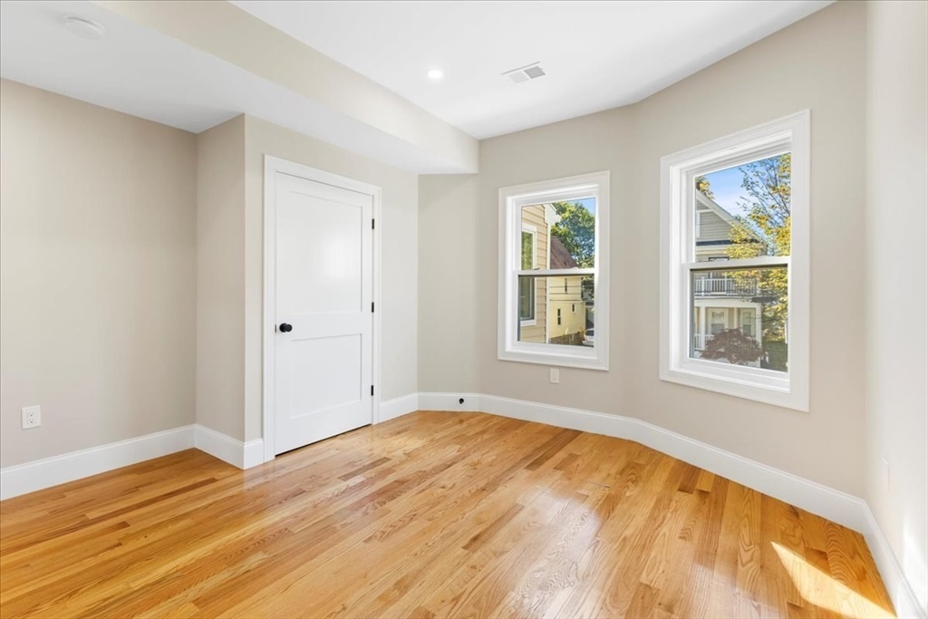 31 Woodale Avenue, Unit 2 Boston, MA 02126 - Photo 10 of 16 a view of empty room with wooden floor and fan