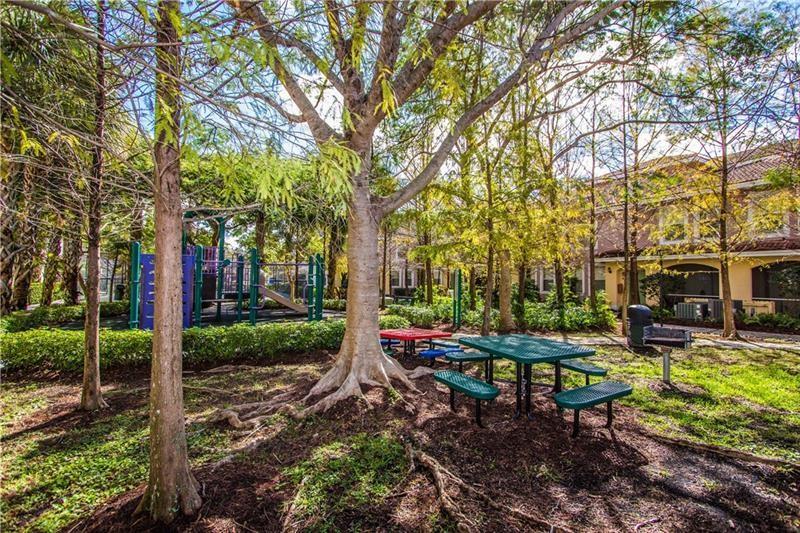 6670 West Sample Road, Unit 6670 Coral Springs, FL 33067 - Photo 12 of 16 a backyard of a house with table and chairs