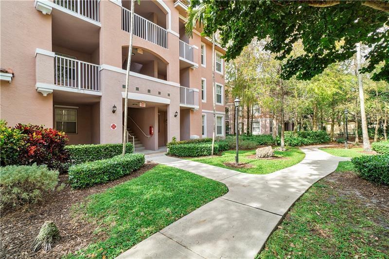 6670 West Sample Road, Unit 6670 Coral Springs, FL 33067 - Photo 2 of 16 a front view of a building with garden