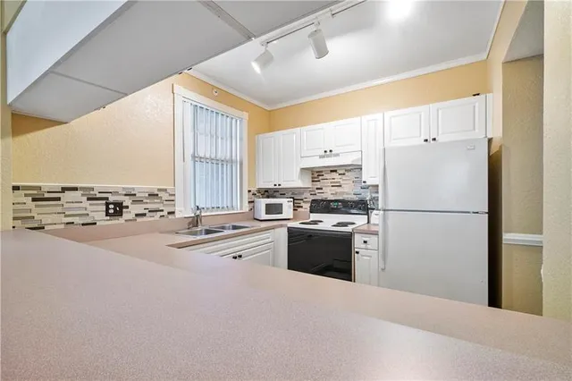 a kitchen with stainless steel appliances a refrigerator sink stove and oven