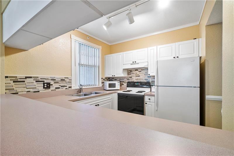 6670 West Sample Road, Unit 6670 Coral Springs, FL 33067 - Photo 6 of 16 a kitchen with stainless steel appliances a refrigerator sink stove and oven