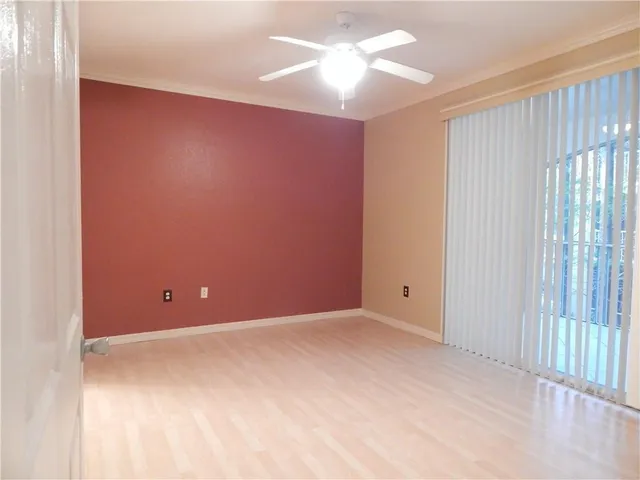 an empty room with chandelier fan