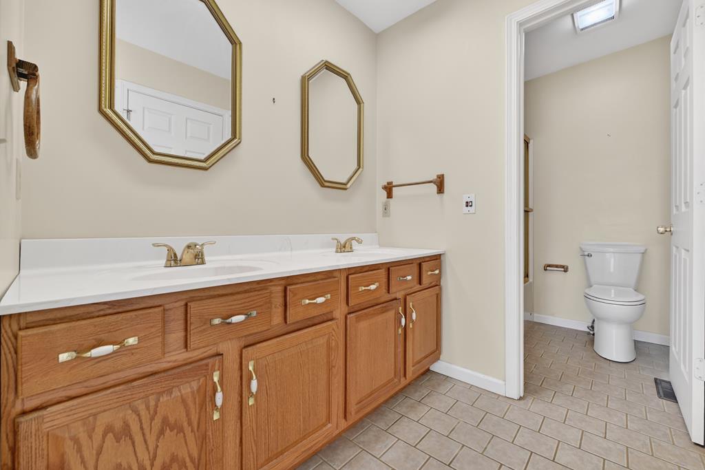 380 La Vista Drive Blue Ridge, GA 30513 - Photo 42 of 48 a spacious bathroom with a double vanity sink a toilet and a mirror