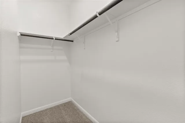 an empty room with closet and windows