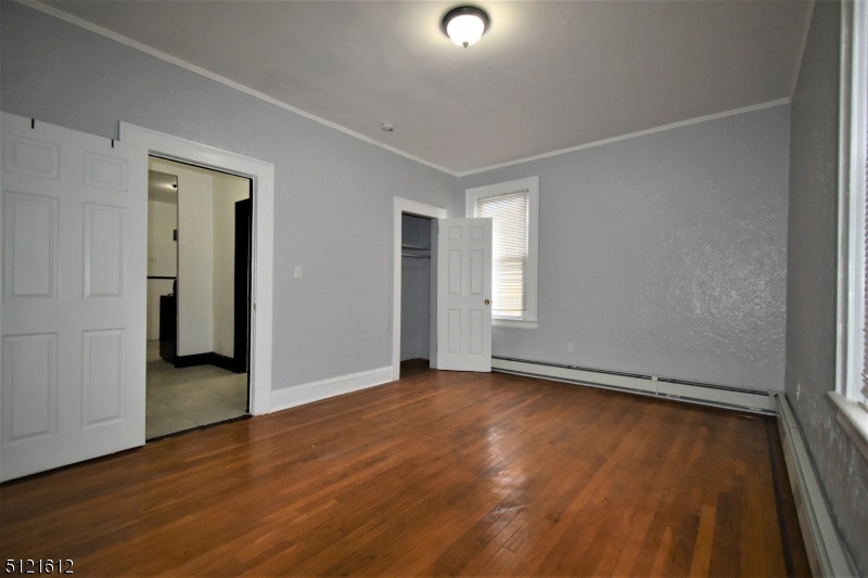 352 Wainwright Street, Unit 1L Newark, NJ 07112 - Photo 5 of 11 an empty room with wooden floor and closet