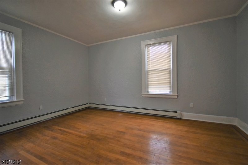 352 Wainwright Street, Unit 1L Newark, NJ 07112 - Photo 6 of 11 an empty room with wooden floor and windows