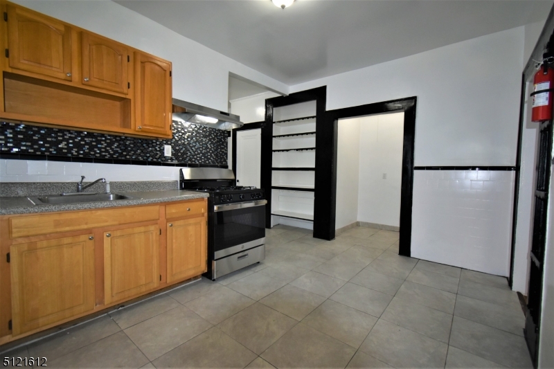 352 Wainwright Street, Unit 1L Newark, NJ 07112 - Photo 7 of 11 a kitchen with stainless steel appliances granite countertop a refrigerator and a sink