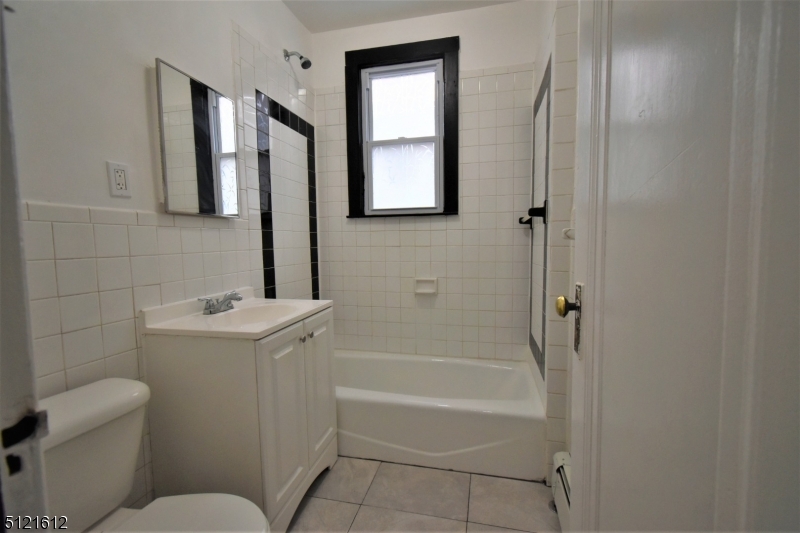 352 Wainwright Street, Unit 1L Newark, NJ 07112 - Photo 10 of 11 a bathroom with a toilet sink and mirror