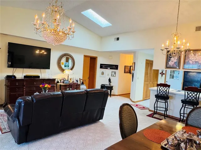 a room with stainless steel appliances kitchen island granite countertop furniture and a refrigerator