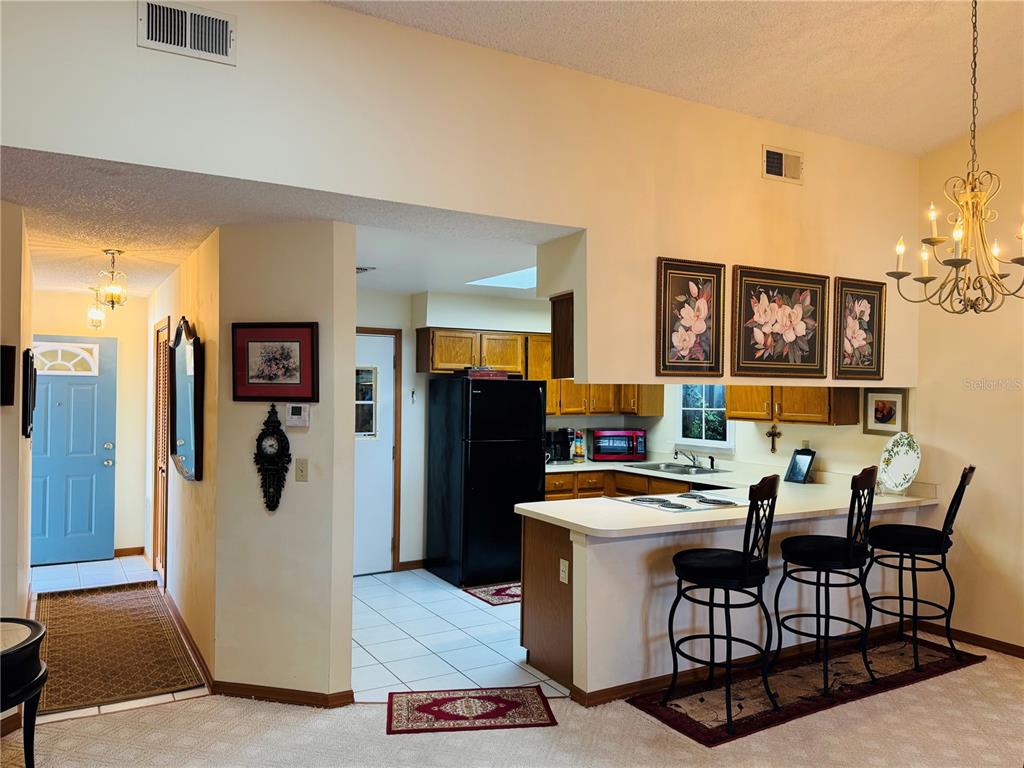 240 Division Street Clermont, FL 34711 - Photo 8 of 16 a room with stainless steel appliances kitchen island granite countertop furniture and a refrigerator