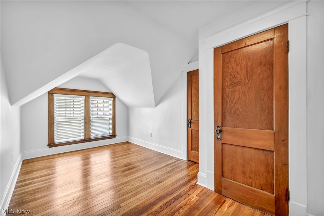 2135 Coventry Road, Unit UP Cleveland Heights, OH 44118 - Photo 29 of 38 Hardwood flooring, painted white walls, two natural wood panel doors, and a double window with natural wood trim