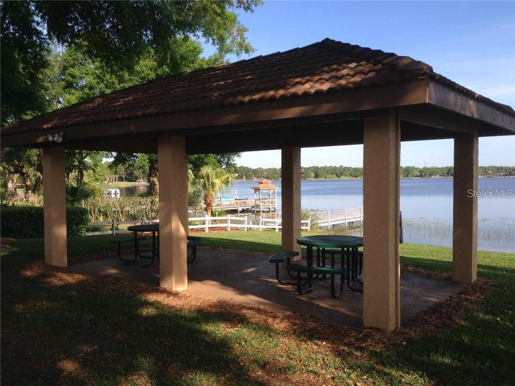 7432 Sparkling Lake Road Orlando, FL 32819 - Photo 53 of 54 a view of a patio with a table chairs and a backyard