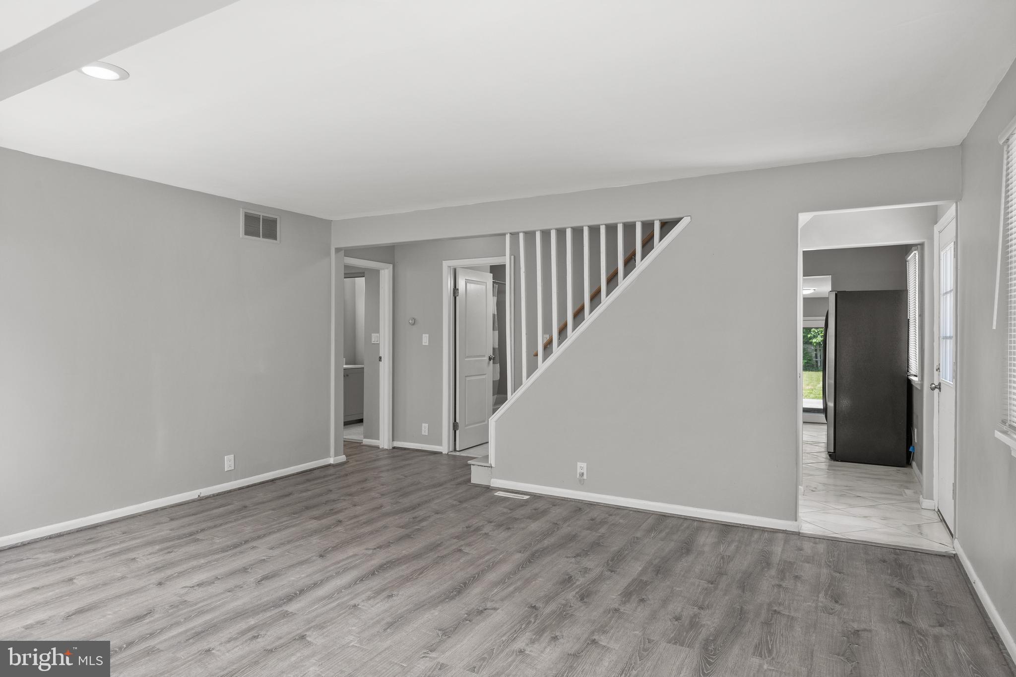 303 Cornell Road Glassboro, NJ 08028 - Photo 6 of 27 a view of an empty room with wooden floor and stairs