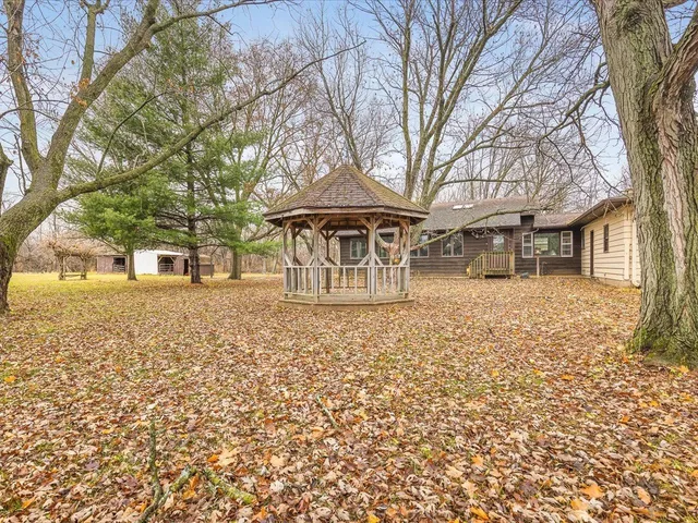 a front view of a house with a yard covered with snow