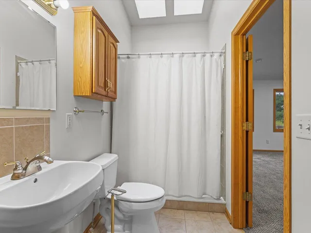 a bathroom with a sink a toilet and mirror