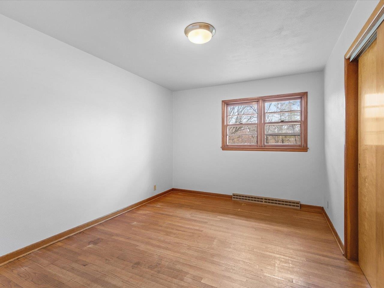7774 Old River Road Rockford, IL 61103 - Photo 31 of 53 an empty room with wooden floor and windows