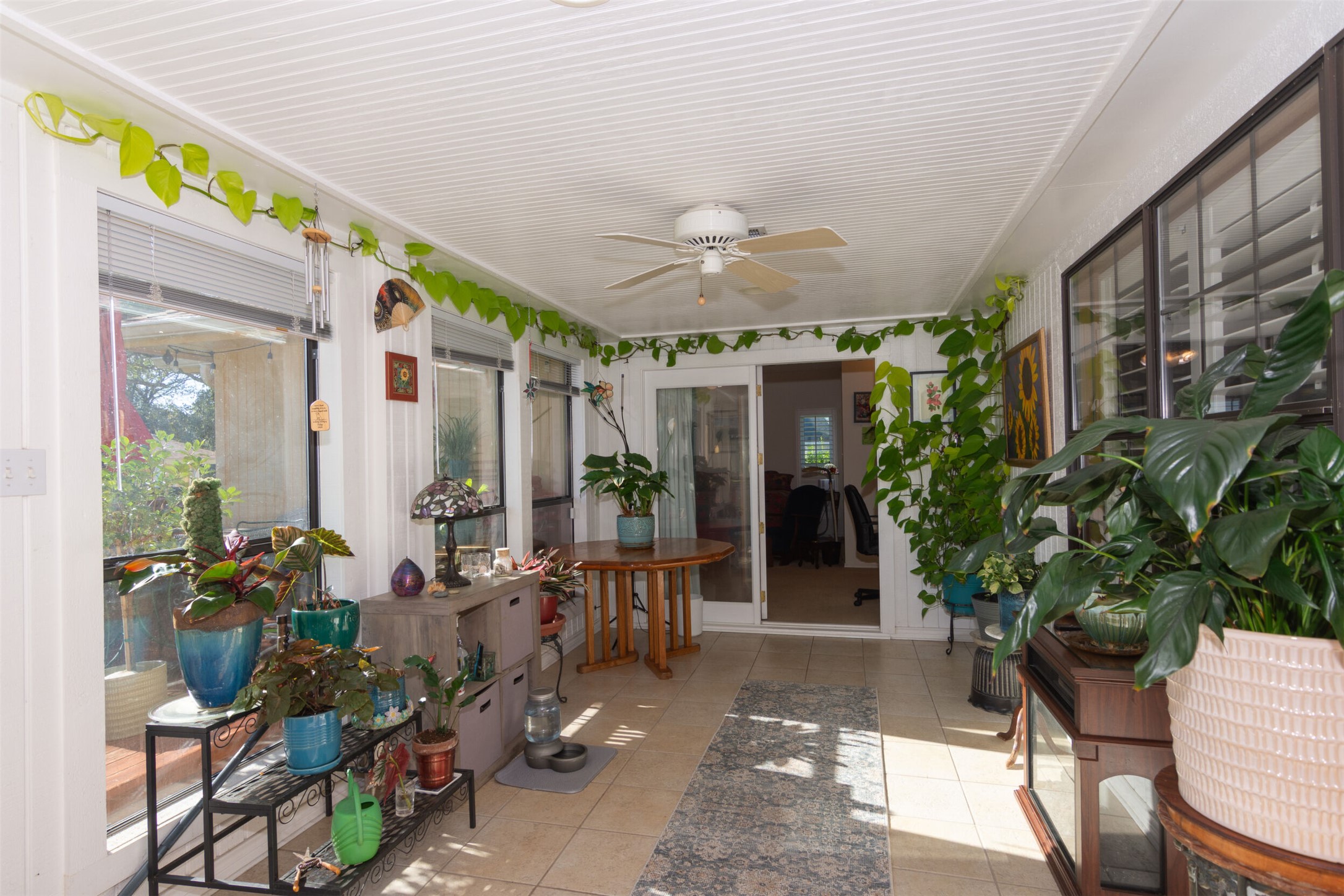 219 Turtle Bend Georgetown, TX 78628 - Photo 21 of 37 A light-filled sunroom features tile flooring, bead board paneled ceilings, and glass doors leading primary suite